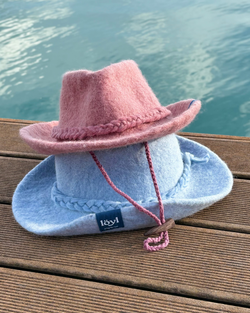 pink and blue wool felt cowboy sauna hats side by side